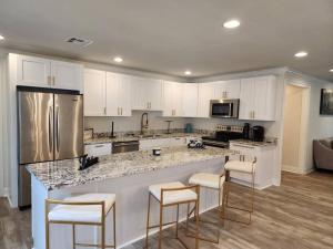 新奥尔良Maison Franklin的一间厨房,配有白色橱柜和一个带酒吧凳的大岛