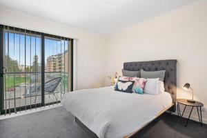 1 dormitorio con cama y ventana grande en Belle Escapes - Glenelg Oceanview Apartment en Adelaida