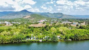 an island in the water with a town and mountains at Kampot Riverfront Boutique in Kampot