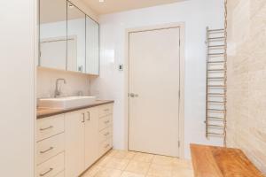 a white kitchen with a sink and a door at Iluka at Blueys Beach in Blueys Beach +11 photos