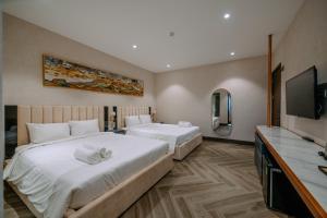 Habitación de hotel con 2 camas y TV de pantalla plana. en La Beaute Hotel Quy Nhơn en Quy Nhon