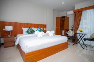 - une chambre avec un grand lit et des draps blancs dans l'établissement The Brown Boutique Patong, à Patong Beach