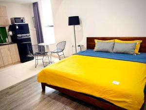 a large yellow bed in a room with chairs at Lynhapartment The Tresor Saigon Disctrict 4 in Ho Chi Minh City