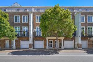 a large brick building with two garage doors and a tree at Chelsea Terrace in Newcastle
