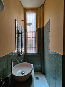 ミラノにあるDarsena apartmentのバスルーム(白い洗面台、窓付)