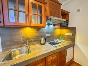 a kitchen with wooden cabinets and a sink at Baron Luxury Boutique in Nuwara Eliya