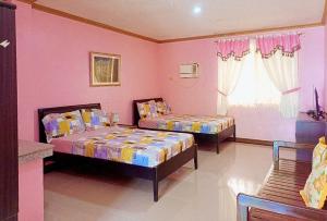 2 camas en una habitación con paredes rosas en Cadaya Resorts 