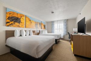a hotel room with two beds and a flat screen tv at Days Inn by Wyndham Wall in Wall
