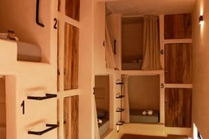 um quarto com portas e prateleiras na parede em Secret Beach Hostel em Puerto Escondido