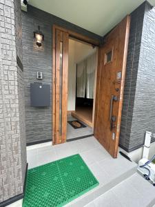 a bathroom with a green mat in front of a door at The Ritz Okinawa Kise 2 in Nago