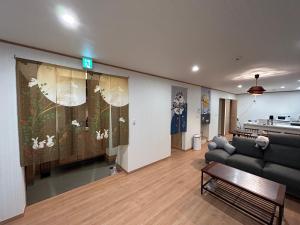 sala de estar con sofá y mesa en The Ritz Okinawa Kise 2 en Nago