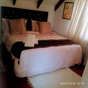 een slaapkamer met een groot bed met witte lakens bij Zagorski bed and breakfast in Kaapstad