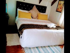 een slaapkamer met een groot wit bed met gele kussens bij Zagorski bed and breakfast in Kaapstad