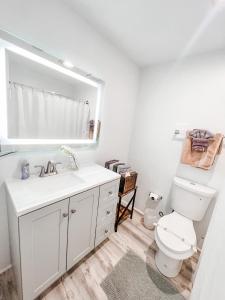 a white bathroom with a toilet and a sink at Gaslamp 2bdrm - W Parking & 4 Beds #204 in San Diego