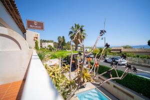 a balcony of a building with a pool and palm trees at Hôtel Beau Soleil in Le Lavandou