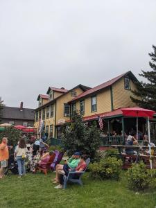 a group of people sitting in lawn chairs in front of a building at Historic 2 Cats Inn in Bar Harbor