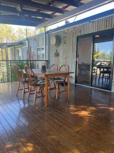a wooden table and chairs on a deck at Hinchinbrook Riverview Retreat in Upper Stone