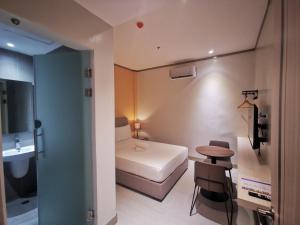 Habitación pequeña con cama y mesa pequeña. en Yes Hotel Imus Cavite, en Imus