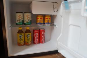 um frigorífico cheio de latas e garrafas de refrigerante em NEW SKY AIRPORT HOTEL NỘI BÀI em Noi Bai