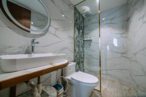 La Beaute Hotel Quy Nhơn في كوي نون: حمام مع حوض ومرحاض ومرآة