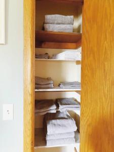 um armário com toalhas brancas numa prateleira em Express Gateway in Stevens Point em Stevens Point