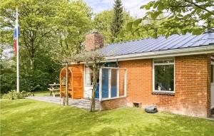 a red brick house with a dog sitting in a window at Awesome Home In Lauwersoog With Kitchen in Lauwersoog