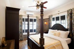 a bedroom with a bed and a ceiling fan at StayVista at The Stone Villa with Basketball Court in Kozhikode