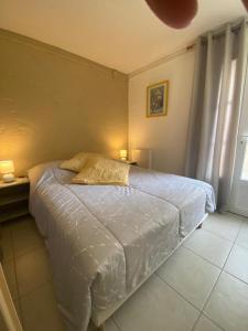 1 cama en un dormitorio con 2 lámparas laterales en Antheor cap Roux, en Saint-Raphaël
