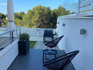 einen Balkon mit zwei Stühlen und einem Tisch darauf in der Unterkunft Ada Vis Apartments in Vis