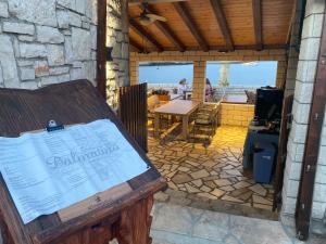a wooden bench in a room with a table and a patio at Ada Vis Apartments in Vis