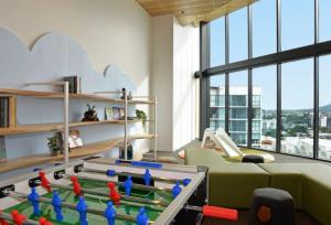 a living room with a pool table in a room with windows at Brand-New Central Studio Apart with Views in Brisbane