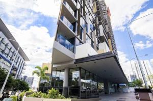a large building with glass windows on a city street at Brand-New Central Studio Apart with Views in Brisbane