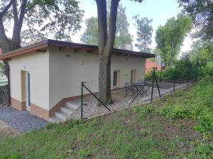 a small white building with a fence around it at Apartmán Esser 5 in Milovice