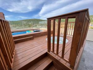 una terraza de madera con piscina en la parte superior. en סוויטות נוף שקיעה, en Peqi‘in H̱adasha