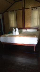 ein großes Bett mit weißer Bettwäsche und Kissen darauf in der Unterkunft Libong Garden Beach in Ko Libong