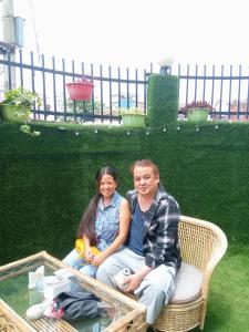mężczyzna i kobieta siedzący na wiklinowej ławce w obiekcie Hotel Krishna Kathmandu w Katmandu