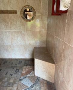 a bathroom with a shower with a bench and a mirror at Sea la vie casita in Las Peñitas