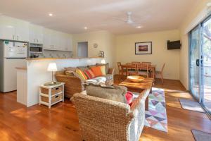 a living room with two couches and a table at Point Break in Boomerang Beach
