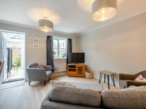 a living room with a couch and a tv at Pebbles in Overstrand