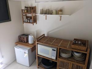 a small kitchen with a microwave and a refrigerator at Large garden block with multiple dwellings in the centre of Bendigo in Bendigo