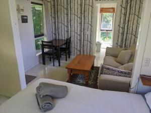 a bedroom with a bed and a couch and a table at Large garden block with multiple dwellings in the centre of Bendigo in Bendigo