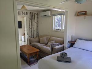a living room with a bed and a couch at Large garden block with multiple dwellings in the centre of Bendigo in Bendigo