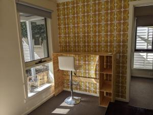 a room with a desk and two windows and a chair at Large garden block with multiple dwellings in the centre of Bendigo in Bendigo