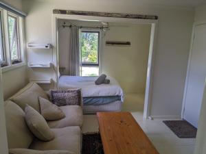 a living room with a couch and a bed at Large garden block with multiple dwellings in the centre of Bendigo in Bendigo