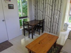 a living room with a wooden table and chairs at Large garden block with multiple dwellings in the centre of Bendigo in Bendigo