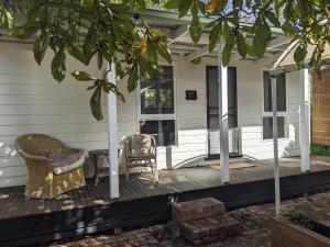 a front porch with two chairs and a table at Large garden block with multiple dwellings in the centre of Bendigo in Bendigo