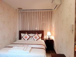een slaapkamer met een groot bed met 2 kussens bij THE RICE HOTEL in Ho Chi Minh-stad