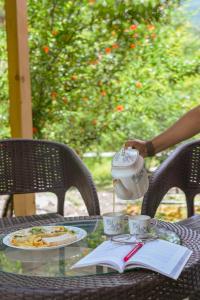 una mesa con un hervidor de agua y un plato de comida en SaffronStays The Elements, en Kulu