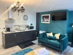 a living room with a blue couch and a sink at Market View 1 in Hexham