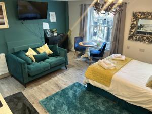 a bedroom with a bed and a couch and a table at Market View 1 in Hexham